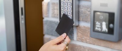 Attaching card to the electronic reader to access the office or apartment, close-up. Card entry, personal identification, keyless access, modern technologies concept